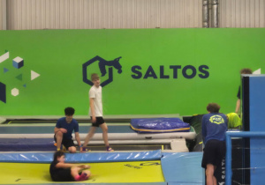 Uczniowie skaczący na trampolinach.