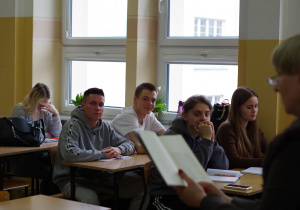 uczniowie w klasie podczas czytania przez nauczyciela książki