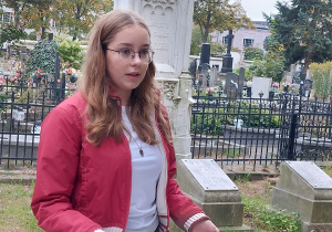 Uczennica prezentuje rodzinę Ludwika Geyera przy ich nagrobku na Starym Cmentarzu w Łodzi.