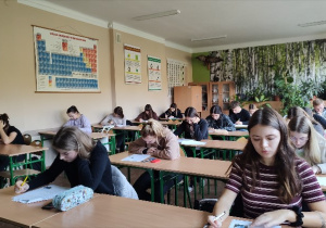 Grupa uczniów w klasie, wypełniająca test zawierający zadania zamknięte podczas I etapu eliminacji