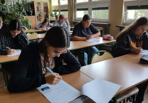 Grupa uczniów w klasie, wypełniająca test zawierający zadania zamknięte podczas I etapu eliminacji
