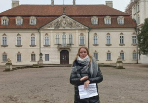 Uczennica prezentuje historię pałacu przed pałacem Radziwiłłów w Nieborowie
