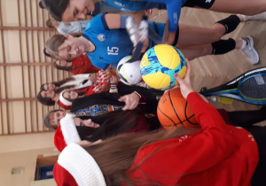 uczniowie w czapkach Mikołaja wręczają nagrody uczestnikom turnieju