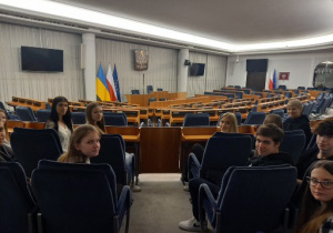 Uczniowie siedzący na fotelach dla publiczności w sali Senatu Rzeczpospolitej