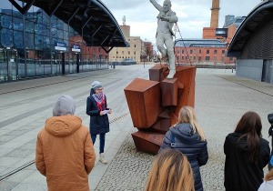 Uczennic prezentuje pomnik Spóźnionego Pasażera przy Dworcu Łódź Fabryczna w Łodzi