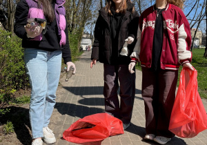 Uczennice podczas zbierania śmieci w parku