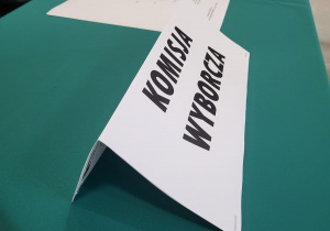 Kartka stojąca na stole z napisem Komisja Wyborcza