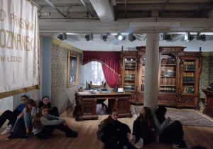 Uczniowie słuchają wykładu podczas wycieczki do Muzeum Włókiennictwa